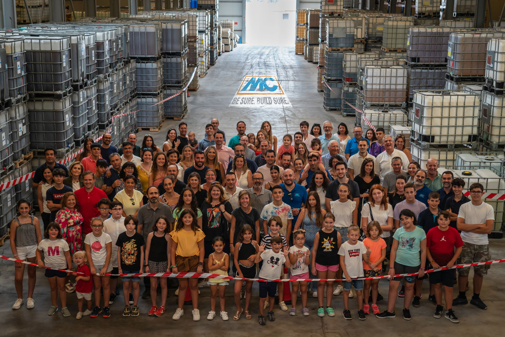Foto final del día de la familia con todos los grandes y pequeños invitados en el almacén de MC España.